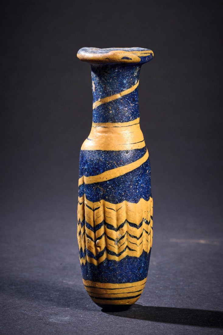 Elegantes Alabastron mit gelbem Federdekor auf kobaltblauem Grund.: Elegantes Alabastron mit gelbem Federdekor auf kobaltblauem Grund. oestlicher Mittelmeerraum, wohl Pantikapaion, 2. - 1. Jh. v. Chr. H 9cm. Kobaltblaues, transluzides Glas von tiefer Farbwirkung.
