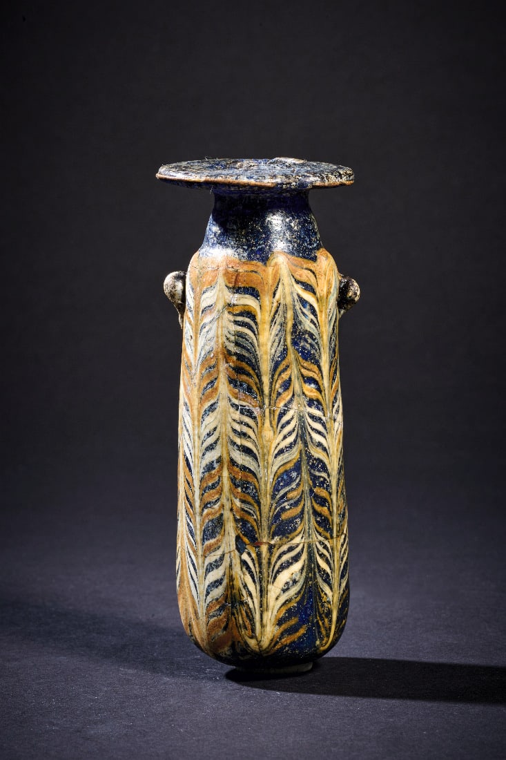 Grosses Alabastron mit Noppenhenkeln.: Grosses Alabastron mit Noppenhenkeln. oestliches Mittelmeergebiet, 3. - 2. Jh. v. Chr. H 12cm. Dickwandiges, blau marmoriertes, opakes Glas. Sandkerntechnik. Schlanker, leicht gestreckter Koerper mit