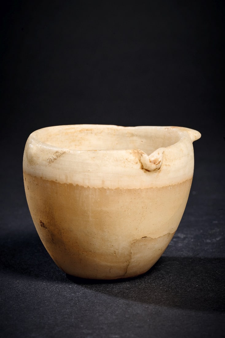 Becher mit Ausguss aus Alabaster.: Becher mit Ausguss aus Alabaster. Fruehdynastisch - Altes Reich, 1. - 3. Dynastie, 3050 - 2614 v. Chr. H 6,3cm, ? 7,1cm. Kraeftig gebaenderter Alabaster mit weissen bis rotbraunen Lagen. Konvexer hohe