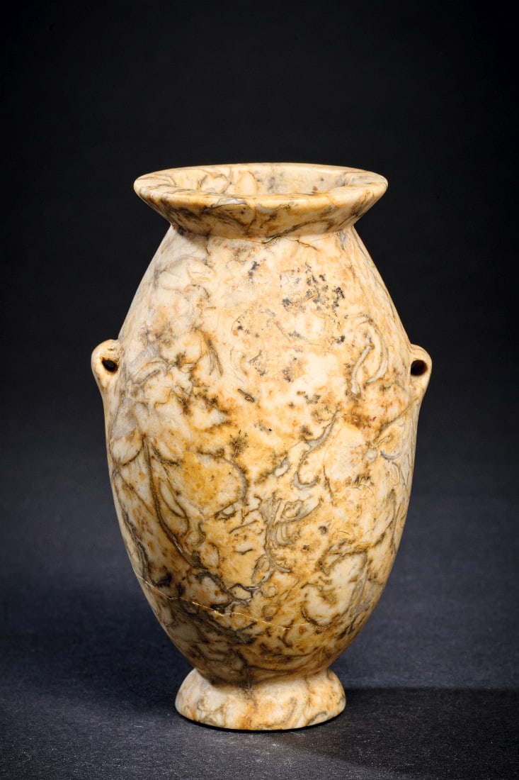 Kleiner Schnuroesentopf.: Kleiner Schnuroesentopf. Naqada I - II, 4000 - 3200 v. Chr. H 9,2cm, ? 5,3cm. Travertin mit herrlicher Maserung. Ovoides Salbgefaess mit konischem Fuss, auskragender Muendung und seitlichen Schnuroese