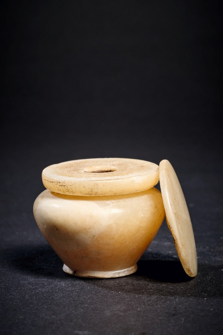 Kleiner Kohl-Topf aus Alabaster.: Kleiner Kohl-Topf aus Alabaster. Mittleres Reich, 2170 - 1794 v. Chr. H mit Deckel 4,3cm, ? 4,9cm. Gebaendeter Alabaster. Konisches Toepfchen mit runder Schulter und separat gearbeiteter tellerfoermig