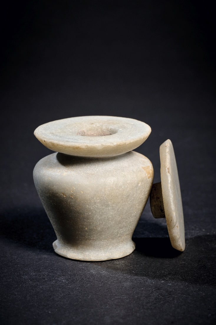 Miniatur-Kohl-Topf mit Deckel aus Anhydrit.: Miniatur-Kohl-Topf mit Deckel aus Anhydrit. Mittleres Reich, 2170 - 1794 v. Chr. H 5,2cm, ? 5,4cm. Konisches Toepfchen mit abgerundeter Schulter und Tellermuendung, darauf flacher Deckel mit Fuehrungs