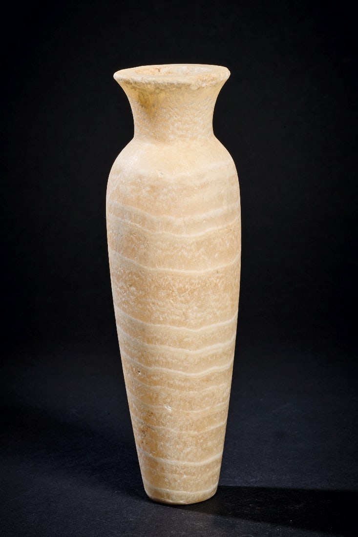 Schlankes Alabastergefaess.: Schlankes Alabastergefaess. Fruehdynastisch - Altes Reich, 2. - 6. Dynastie, 2850 - 2218 v. Chr. H 17,8cm, ? 5,8cm. Schoen gebaenderter Alabaster. Leicht konischer Koerper mit runder Standflaeche, obe