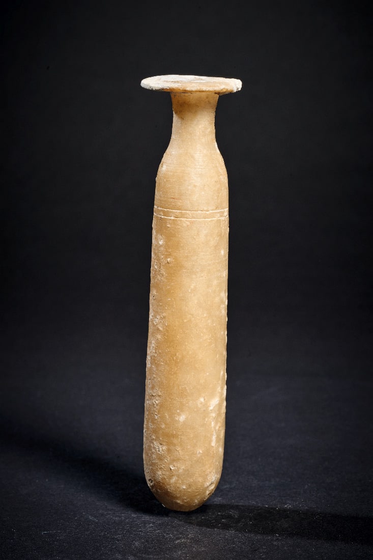 Schlankes Alabastron.: Schlankes Alabastron. Ptolemaeisch, 332 - 30 v. Chr. H 13,5cm, ? 3,1cm. Schlankes Salbgefaess mit Tellermuendung. Unter der Schulter zwei abgedrehte Rillen. Teil des Tellers ergaenzt, im unteren Teil