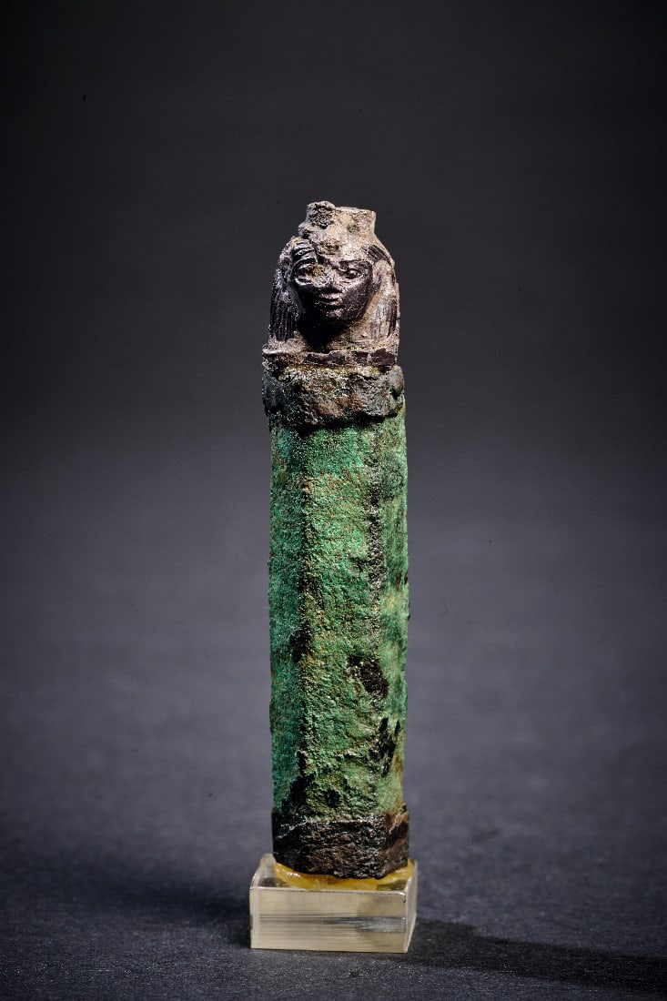 Kapsel-Anhaenger mit Kopf einer Goettin.: Kapsel-Anhaenger mit Kopf einer Goettin. Neues Reich, 18. Dynastie , 1550 - 1295 v. Chr. L 6,5cm (mit Sockel), L 5,8cm (ohne Sockel). Roehre aus Bronze mit fuenfeckigem Querschnitt, bekroent von