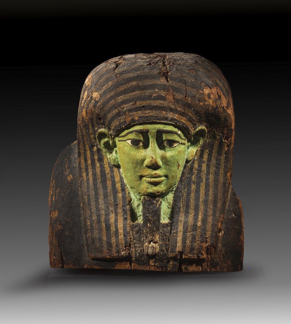 Monumentales Sarkophagdeckeloberteil.: Monumentales Sarkophagdeckeloberteil. Spaetzeit - Ptolemaeerzeit, 1. Jt. v. Chr. H 64cm, B 57cm, T 35cm. Holz mit bemaltem Stuck. Der Verstorbene traegt einen Goetterbart und eine Peruecke, die mit
