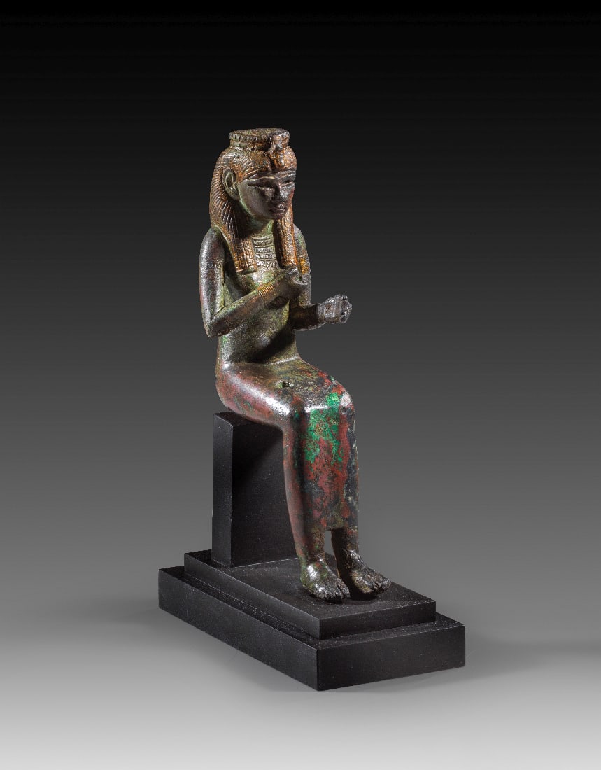 Bronzestatuette der Isis.: Bronzestatuette der Isis. 3. Zwischenzeit bis fruehe Spaetzeit, 22. - 26. Dynastie, ca. 945 - 525 v. Chr. H 15,5cm, H mit Sockel 18cm. Sitzende Isis, deren rechte Hand an die entbloesste Brust