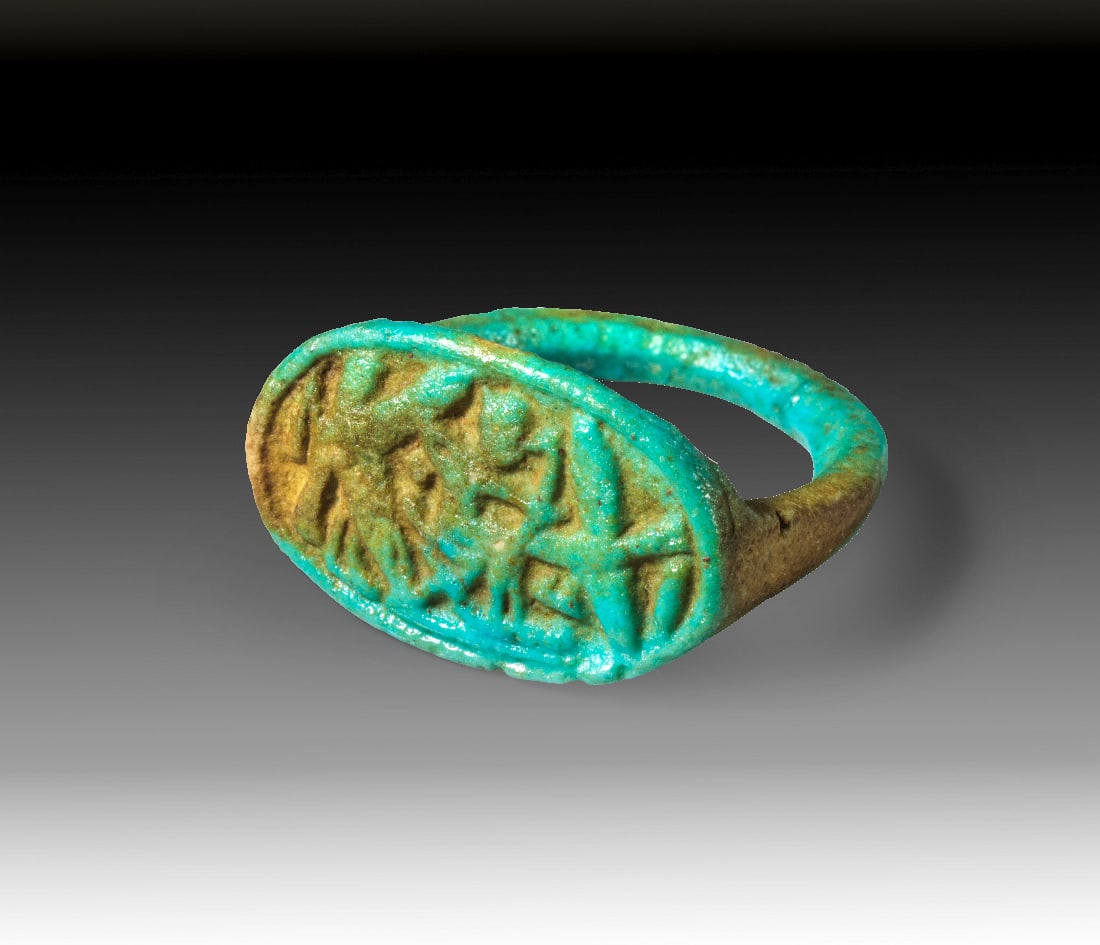Fayence-Ring aus der Armanaperiode.: Fayence-Ring aus der Armanaperiode. Neues Reich, spaete 18. Dynastie, um 1350 v. Chr. Ringgroesse 54. Aus tuerkiser Fayence. Gleichmaessig breite Schiene mit ovaler Platte, darauf dargestellt der