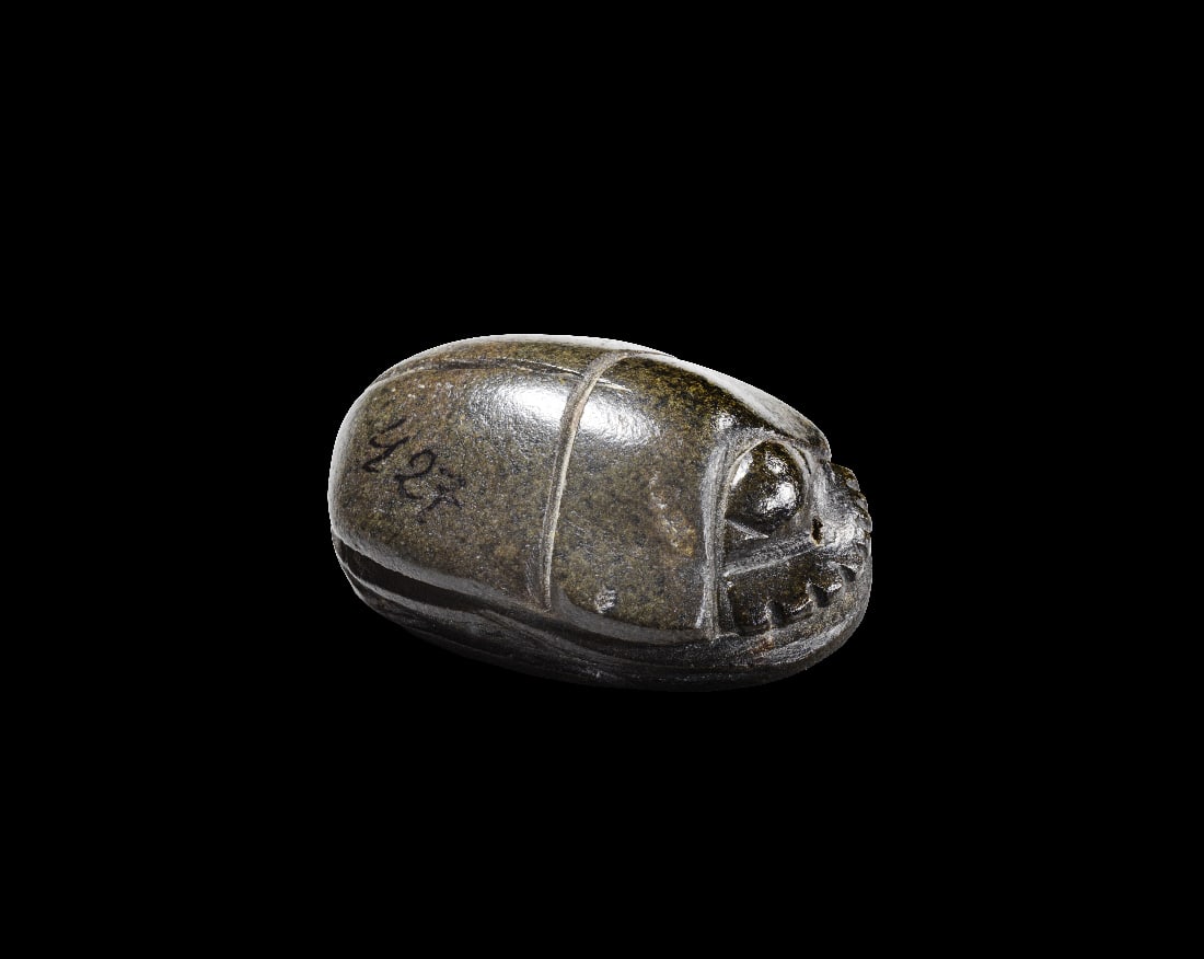 Skarabaeus aus Diorit.: Skarabaeus aus Diorit. Zweite - dritte Zwischenzeit, 15. - 21. Dynastie. L 3,5cm, B 2,4cm, H 1,4cm. Auf der Unterseite glatt, ohne Bohrung. Mit einfacher Binnenzeichnung. Sehr gute Erhaltung, mit