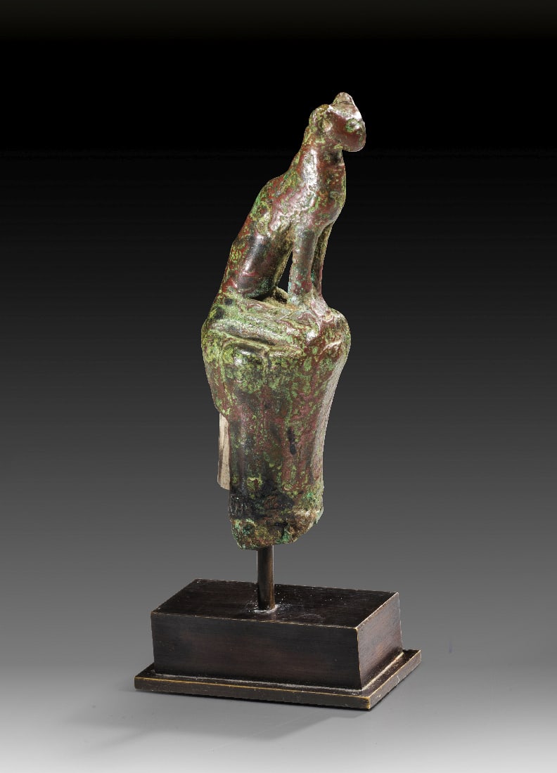 Bronzestatuette der Bastet auf Lotussaeule.: Bronzestatuette der Bastet auf Lotussaeule. Spaetzeit, 664 - 30 v. Chr. H 11cm, H mit Sockel 14,9cm. Statuette der Goettin Bastet in Gestalt eine Katze auf einer Lotussaeule. Teils gruene Patina,