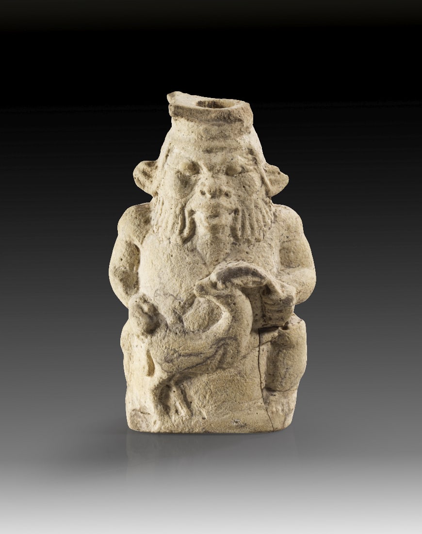 Bes.: Bes. Ptolemaeerzeit, ca. 330 - 30 v. Chr. Kalkstein oder Fayence. H 5,4cm. Figuerliches Gefaess in Form des zwergenhaften Gottes, der eine Antilope in den Haenden haelt. Geklebte Spruenge, Teile der