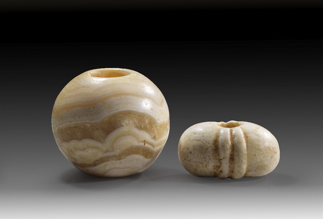 Zwei Keulenkoepfe.: Zwei Keulenkoepfe. Praedynastisch, 3500 - 3000 v. Chr. a) ? 7cm. Kugeliger Keulenkopf aus gebaendertem Alabaster. Intakt. b) ? 6cm. Ovaler Keulenkopf aus Alabaster mit seitlichen Rippen. Intakt. 2
