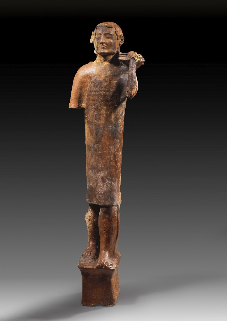 Gabentraeger.: Gabentraeger. Phoenizien, ca. 1. Haelfte 5. Jh. v. Chr. Rotbraune Terrakotta, H 86cm. Ein stehender Mann gekleidet in eine knielange, langaermlige, glatt herabfallende Tunika. Der linke Fuss ist in de