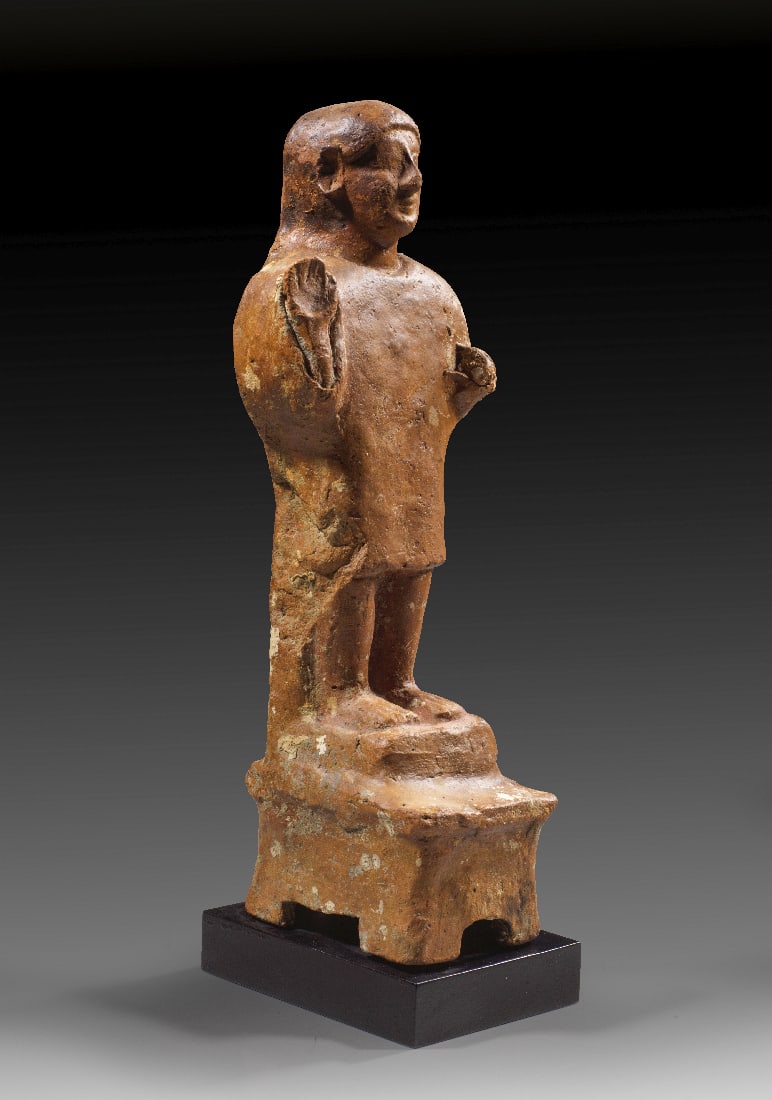 Adorant mit erhobener Hand.: Adorant mit erhobener Hand. Phoenizien, ca. Ende 6. / 1. Haelfte 5. Jh. v. Chr. Rotbraune Terrakotta, H 39cm. Ein stehender junger Mann gekleidet in eine glatte, knielange Tunica mit engem
