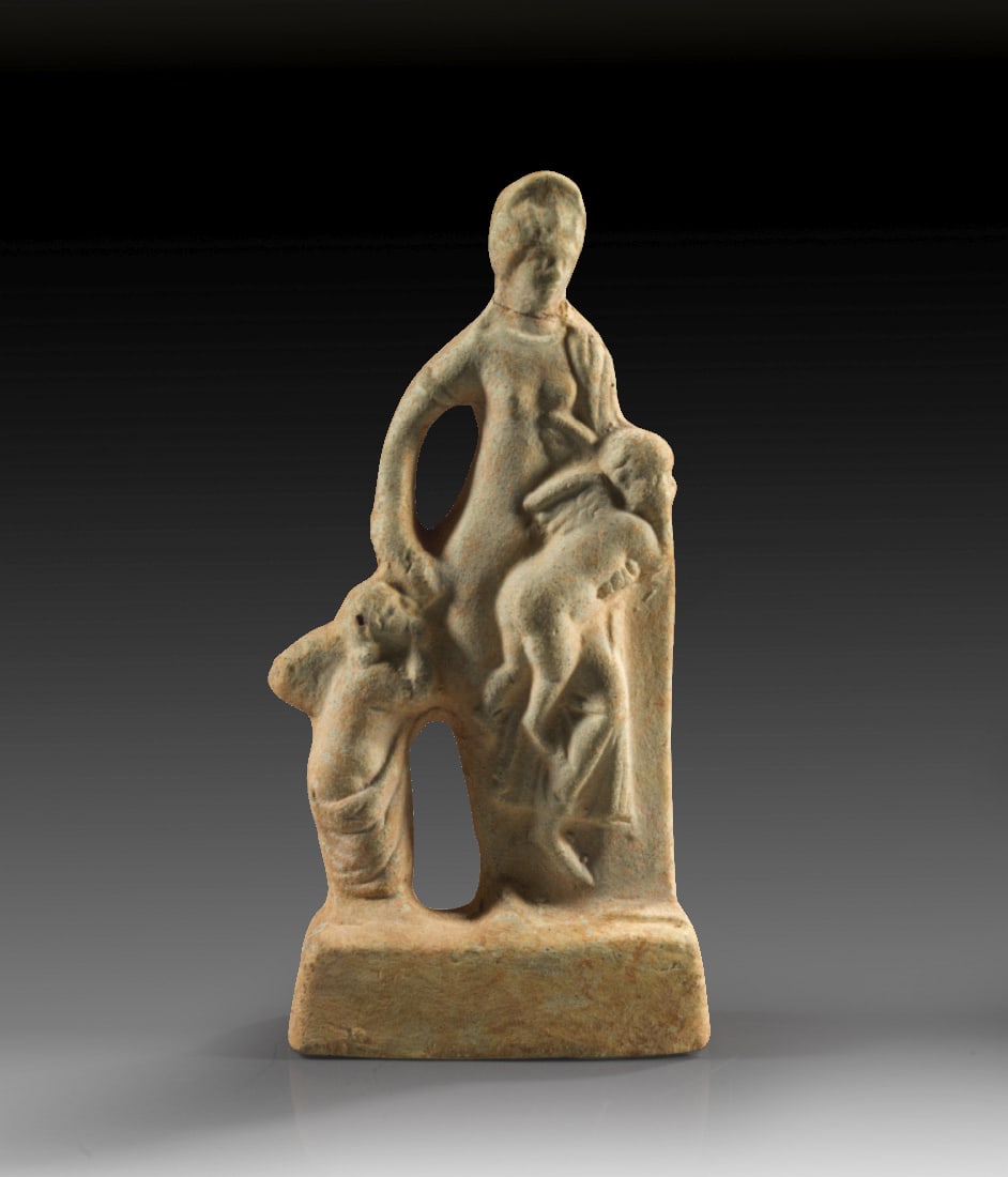 Statuettengruppe mit Venus.: Statuettengruppe mit Venus. Roemisch, 2. - 3. Jh. n. Chr. H 16cm, B 8cm. Hellbeiger Ton mit rotem ueberzug. Matrizengeformt, rueckwaertig ein Brennloch. Venus steht an einen Pfeiler gelehnt, die Recht