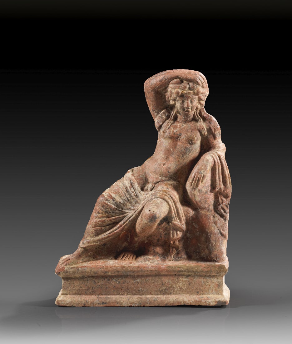 Trunkener Dionysos mit vergoldetem Diadem.: Trunkener Dionysos mit vergoldetem Diadem. Myrina, 2. - 1. Jh. v. Chr. H 17,5cm. Weiss grundierte Terrakotta. Reste von Polychromie und Vergoldung. Der jugendliche Dionysos lagert auf einem Felsen,
