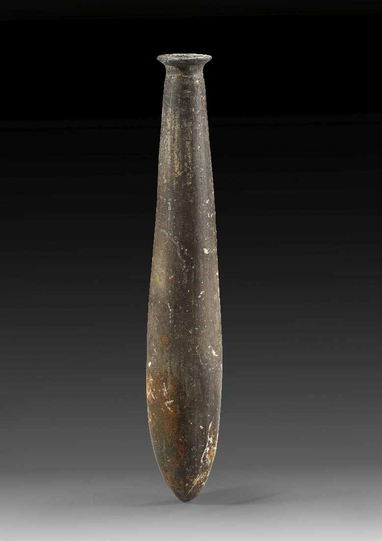 Seltenes etruskisches schlankes Alabastron.: Seltenes etruskisches schlankes Alabastron. 7. Jh. v. Chr. H 20,6cm. Tropfenfoermiges Salbgefaess mit kleiner Muendung und spitzem Boden aus dunkelbraunem Impasto. Mit Kopie des Lieferscheines von
