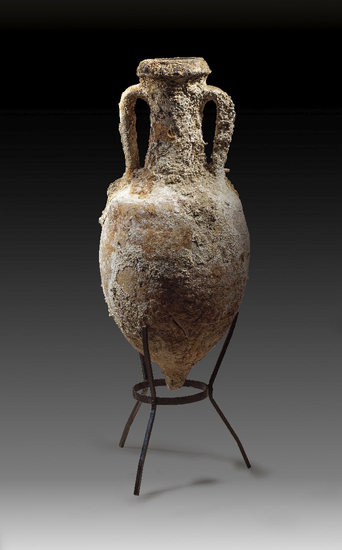 Roemische Transportamphora Typus Lamboglia 2 fuer Olivenoel.: Roemische Transportamphora Typus Lamboglia 2 fuer Olivenoel. Adriakueste, 1. Jh. v. Chr. H 83,5cm und mit Staender 104cm. Beiger Ton. Ovoider Koerper mit abgesetzter Schulter, Schornsteinhals, hohen