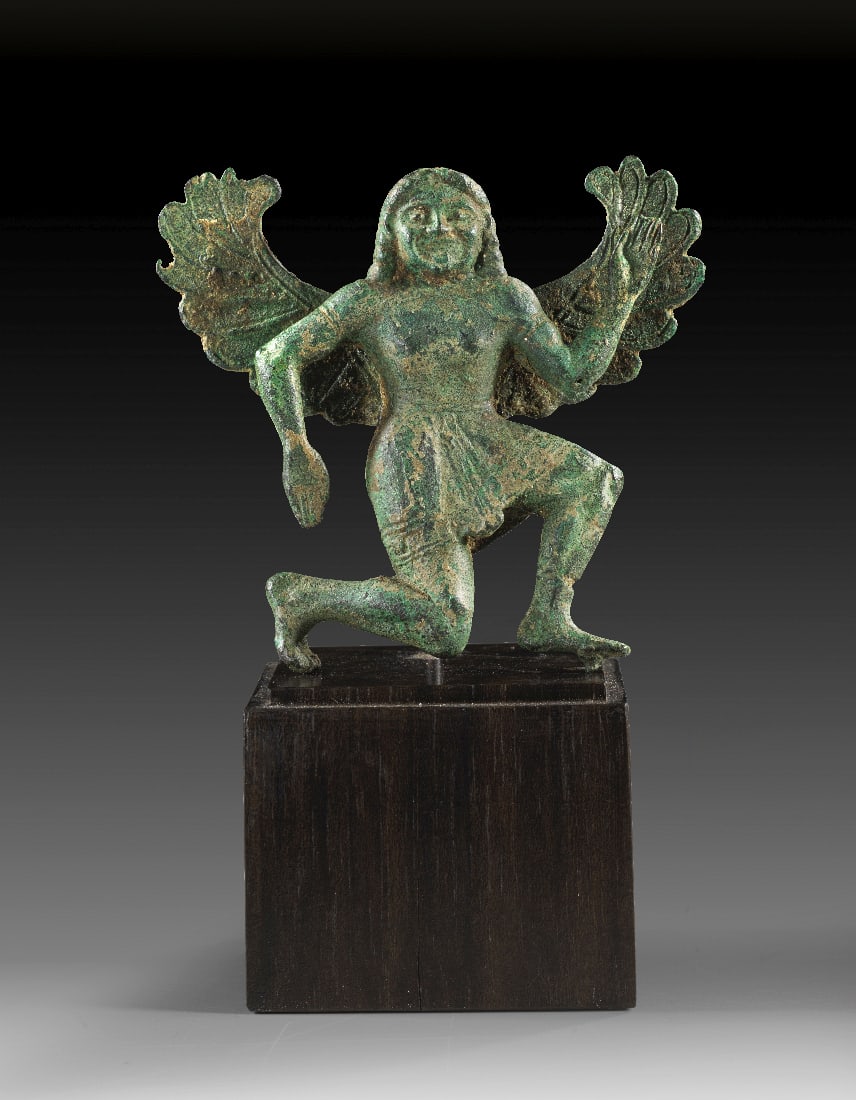 Gorgo Medusa.: Gorgo Medusa. Griechenland, um Anfang 5. Jh. v. Chr. H 7,1cm B 7,7cm. Bronzevollguss. Vollplastischer Geraeteaufsatz in Form der gefluegelten, im Knielaufschema nach rechts eilenden Medusa in kurzem,