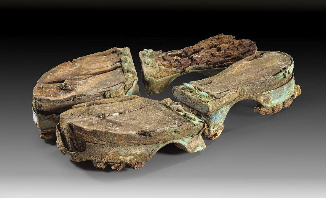 Paar etruskischer Sandalen fuer Frauen aus Holz.: Paar etruskischer Sandalen fuer Frauen aus Holz. 6. Jh. v. Chr. Die Schuhe bestehen jeweils aus zwei Teilen. Unter einer Lage Holz befindet sich sowohl bei Zehen- wie auch Fersenteil ein bronzener