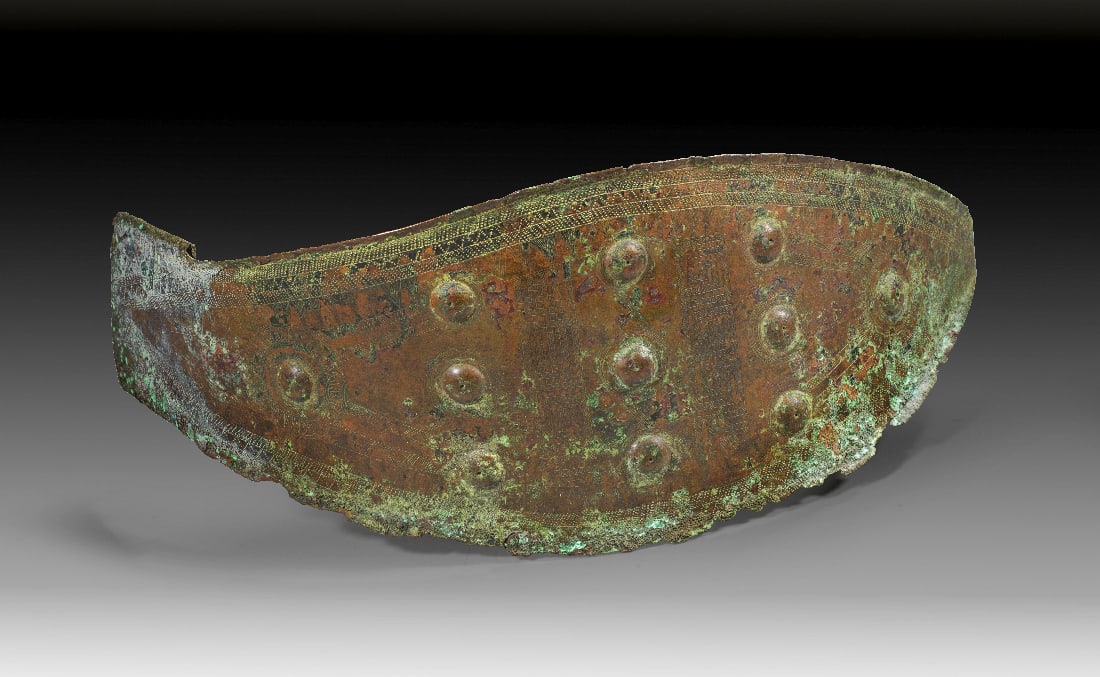 Grosse bronzene Guertelschliesse aus der Villanova-Kultur.: Grosse bronzene Guertelschliesse aus der Villanova-Kultur. 8. Jh. v. Chr. H 12,8cm, L 42,7cm, B 30,5cm. Spitzovales Bronzeblech mit 11 Buckeln in drei Reihen und feinem gestichelten geometrischen Deko
