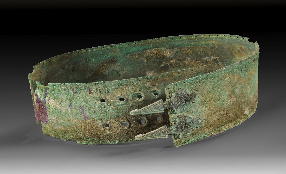 Samnitischer Bronzeguertel.: Samnitischer Bronzeguertel. 4. Jh. v. Chr. H 8,9cm, L 84,1cm. Duennes Bronzeblech mit Nietreihen oben und unten. An einem Ende in zwei Reihen acht Loecher fuer die Aufnahme der beiden Guertelhaken, di