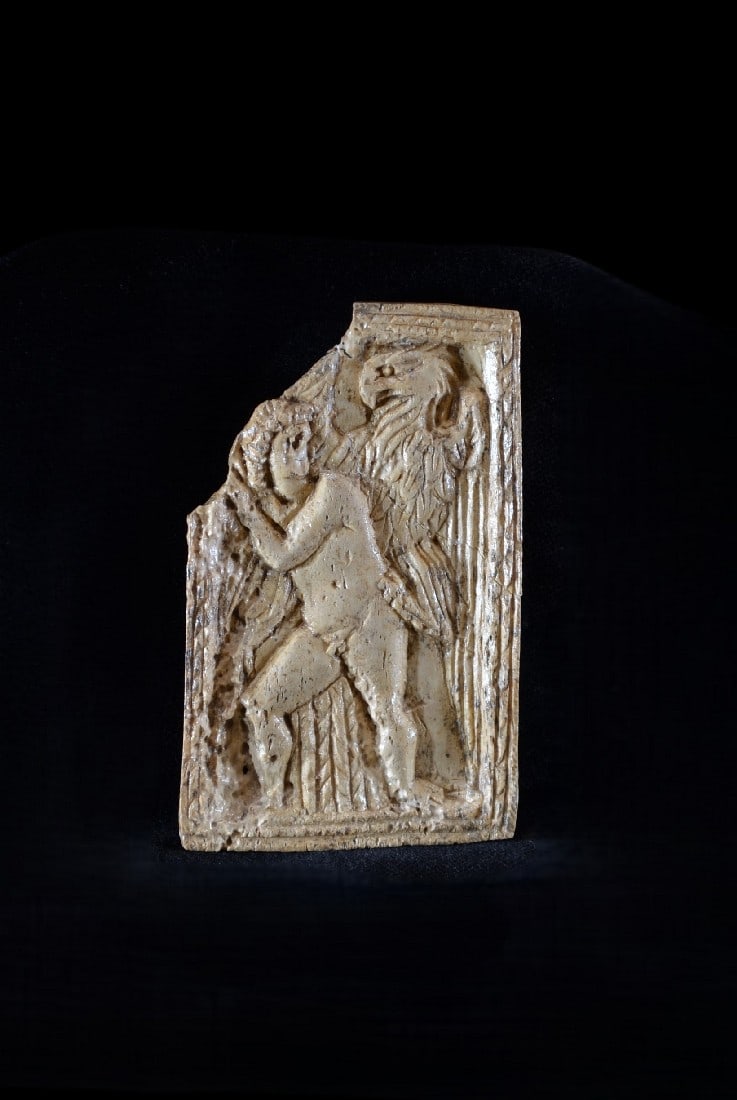 Plakette mit Ganymed.: Plakette mit Ganymed. Roemisch, 3. Jh. n. Chr. H 7,8cm, B 5cm. Bein. Rechteckige Plakette - wahrscheinlich ein Kaestchenbeschlag - mit geriefeltem Rahmen, darauf Ganymed und Zeus in Gestalt des