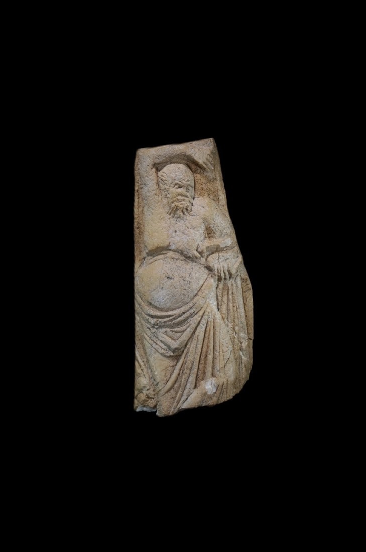 Relief mit Silen.: Relief mit Silen. Romano-aegyptisch, 3. - 4. Jh. n. Chr. H 11,5cm, B 5,5cm. Bein. Dargestellt ist ein baertiger Silen, der einen Mantel um die Hueften geschlungen hat, und in der linken Hand eine