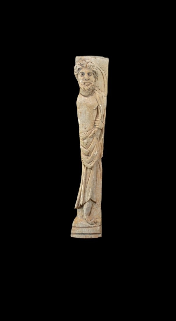 Relief mit Baertigem.: Relief mit Baertigem. Romano-aegyptisch, 3. - 4. Jh. n. Chr. H 18cm, B 3,5cm. Bein. Unter einem Bogen stehende, maennliche, baertige Figur, der Mantel um die Hueften geschlungen und ueber die
