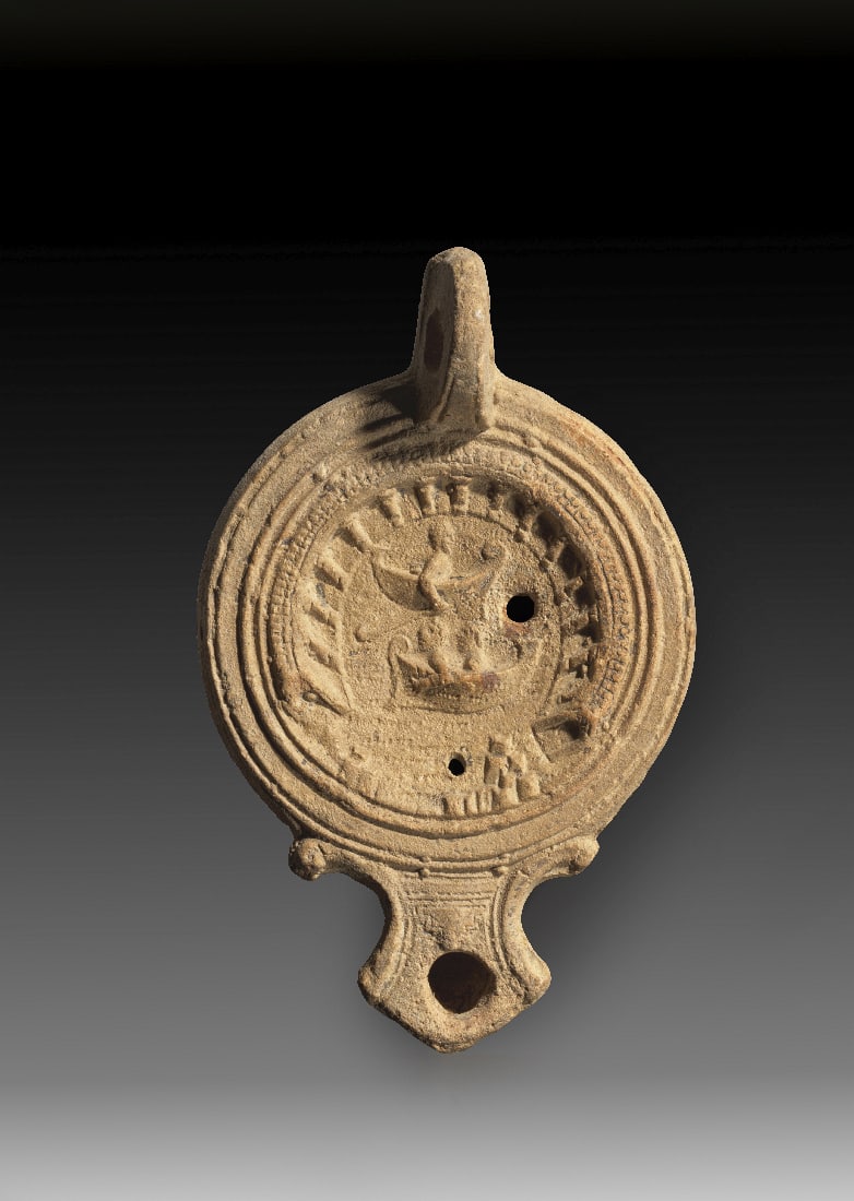 Tonlampe mit Schiffen und Hafen.: Tonlampe mit Schiffen und Hafen. Roemisch, 2. Jh. n. Chr. Loeschcke Typ IC. L 14cm, H 3cm. Aus beigem Ton mit beigem ueberzug. Runder Corpus mit eckiger Volutenschnauze mit rundem Brennloch und Griffh
