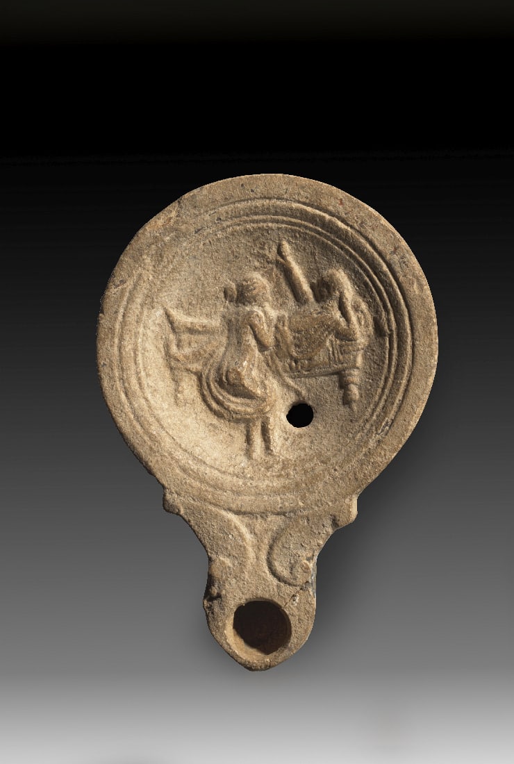 Tonlampe mit Liebespaar bei der Fellatio.: Tonlampe mit Liebespaar bei der Fellatio. Roemisch, 1. Jh. n. Chr. Loeschcke Typ IV, Schulter Typ IIIa. L 11cm, B 7,5cm. Aus beigem Ton mit beigen ueberzug. Runder Corpus mit runder Volutenschnauze mi