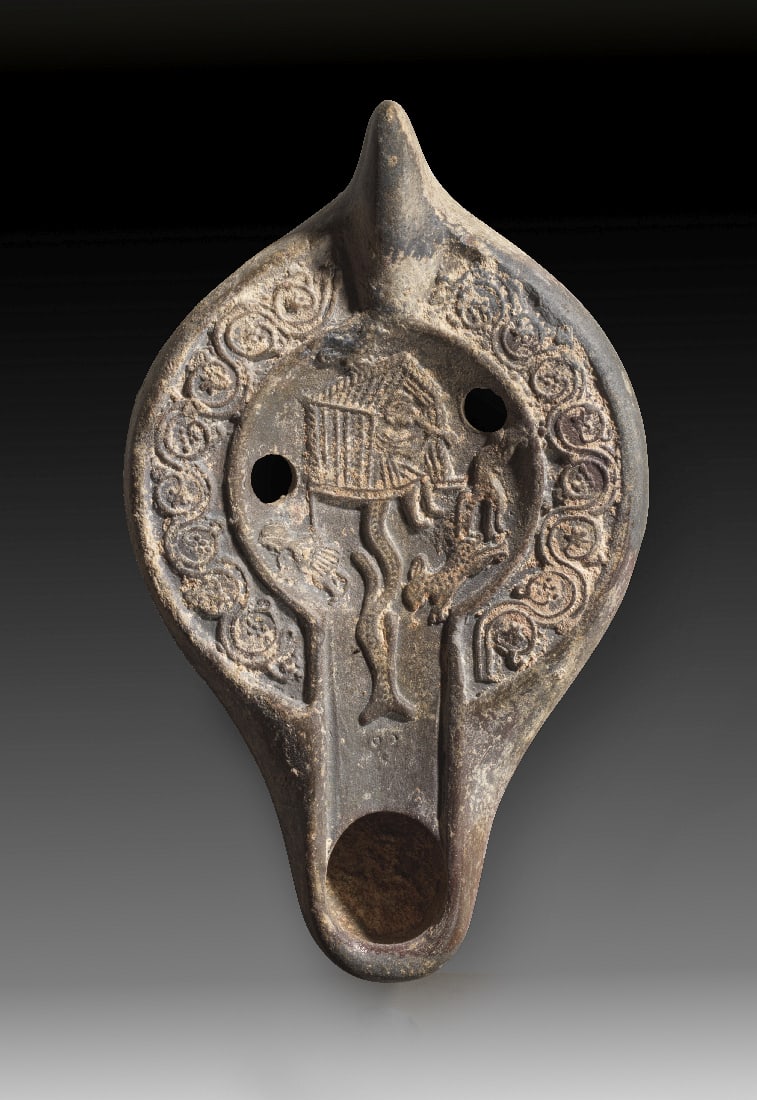 Spaetantike Tonlampe mit Schutzhuette im Weinberg.: Spaetantike Tonlampe mit Schutzhuette im Weinberg. Nordafrika, 4. - 5. Jh. n. Chr. Typ Hayes II. L 14cm, H 3,3cm. Aus beigem Ton mit dunkelbraunem ueberzug. Zapfenfoermiger Griff, eifoermiger Corpus