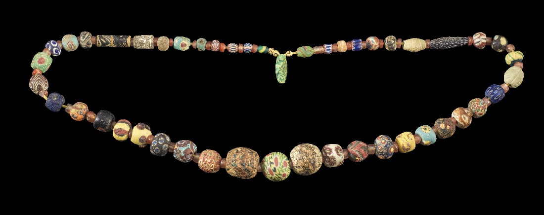 Halskette mit Millefiori-Glasperlen.: Halskette mit Millefiori-Glasperlen. Roemisch, 100 v. Chr. - islamisch, 1000 n. Chr. L ca. 96cm. Aus kugeligen und roehrenfoermigen, mehrfarbigen Glasperlen mit verschiedenen Mustern. Dazwischen