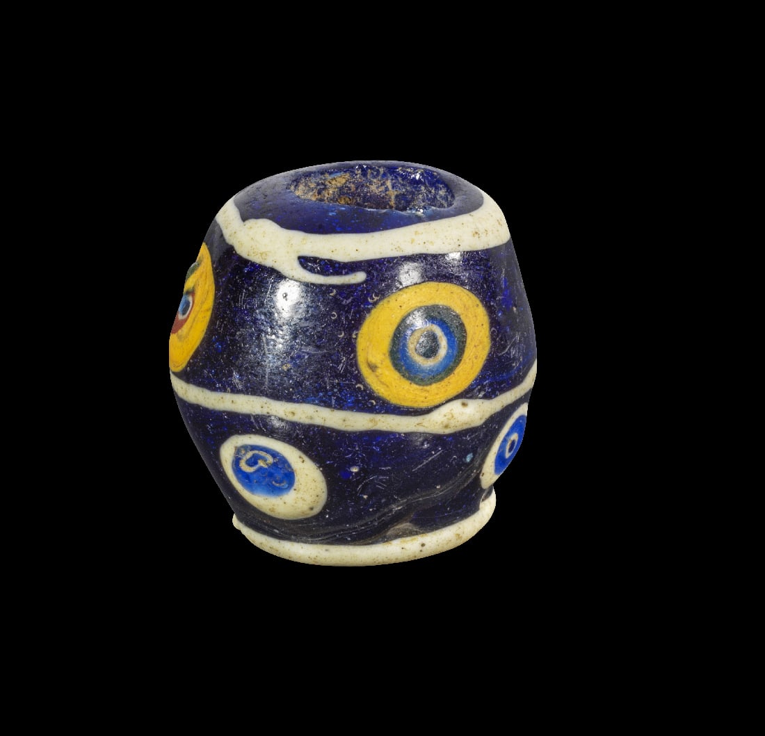 Grosse Glasperle mit Augen.: Grosse Glasperle mit Augen. Phoenizisch, 4. - 3. Jh. v. Chr. H 3,1cm, ? 3,2cm. Bikonisch und aus dunkelblauem Glas, Augen aus weissem, dunkel- und hellblauem sowie partiell aus gelben Glas. Intakt. Pr
