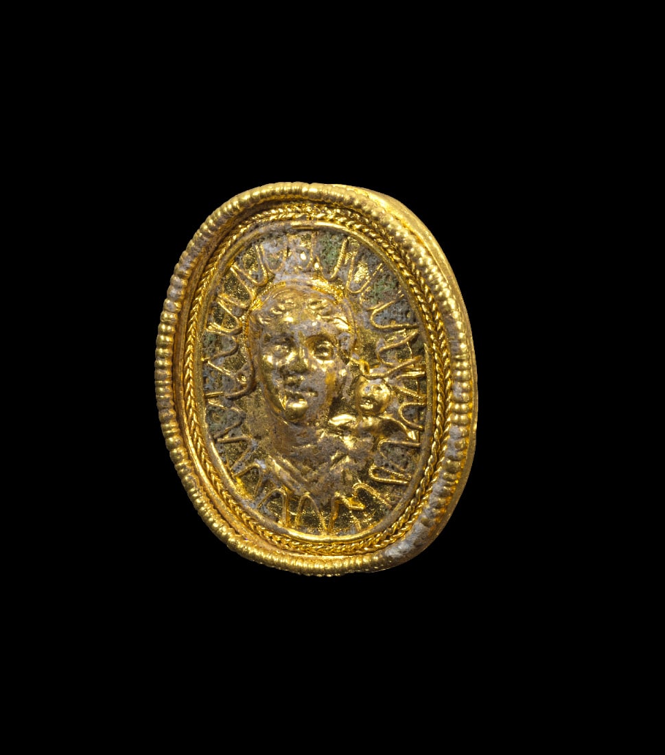 Goldring mit Aphrodite und Eros.: Goldring mit Aphrodite und Eros. Hellenistisch, 3. Jh. v. Chr. 18,42g, Ringgroesse 50. Breite Bandschiene, darauf eine hochovale Platte mit einem Relief aus gepraegter Goldfolie, umgeben von Zungenmus