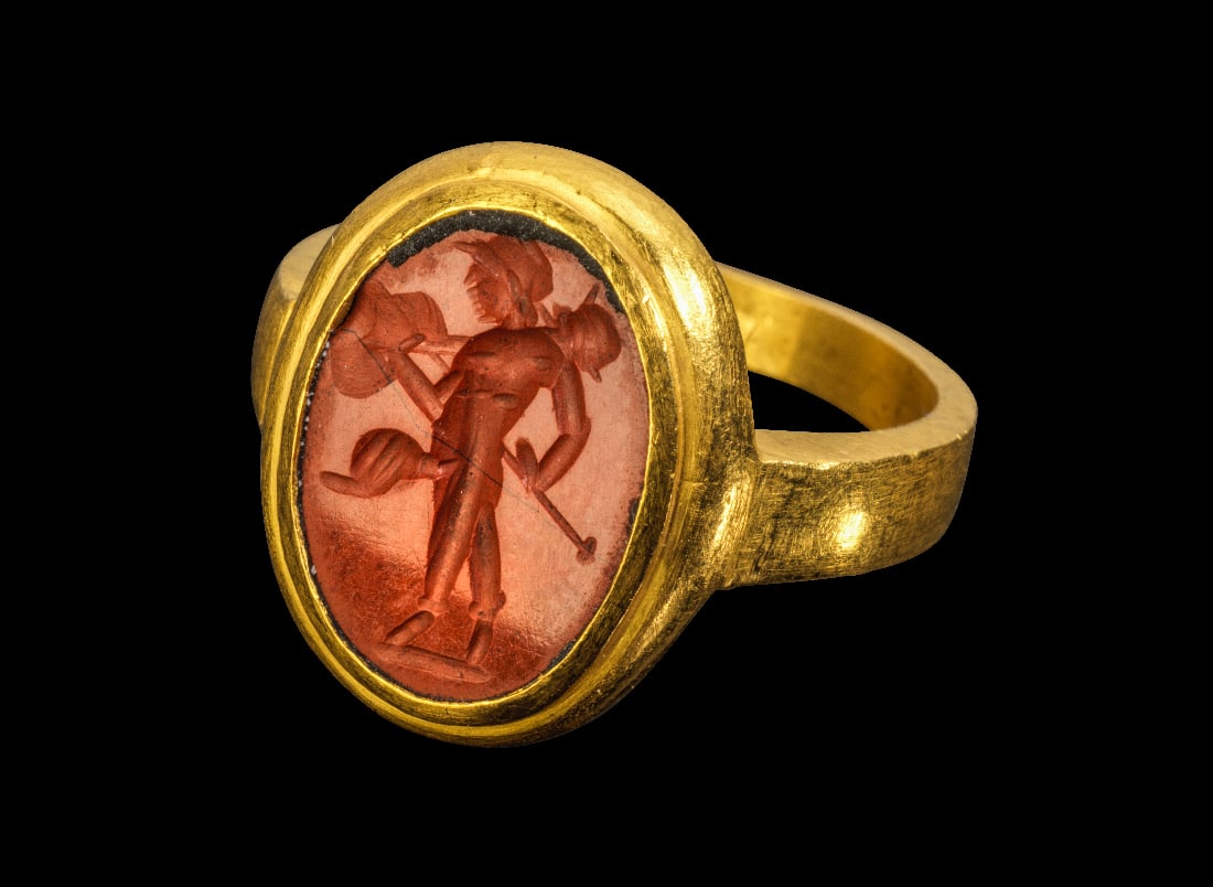 Moderner Goldring mit antiker Jaspisgemme mit Mars.: Moderner Goldring mit antiker Jaspisgemme mit Mars. Gemme roemisch, 1. - 2. Jh. n. Chr. 10,72g, Ringgroesse 54-55. Goldring mit nach oben breiter werdender Schiene, auf der Aussenseite zwei Punzen. Au