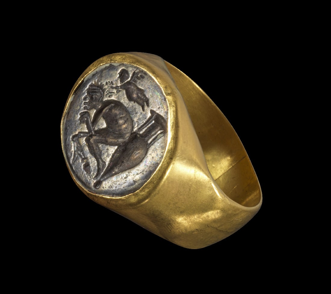Moderner Goldring mit Silber-Gemme.: Moderner Goldring mit Silber-Gemme. Roemisch, 2. - 3. Jh. n. Chr. 10,33g, Ringgroesse 57. Gleichmaessig breite Bandschiene, auf der Platte eingelassen eine Gemme aus Silber. Darauf ein auf einer liege