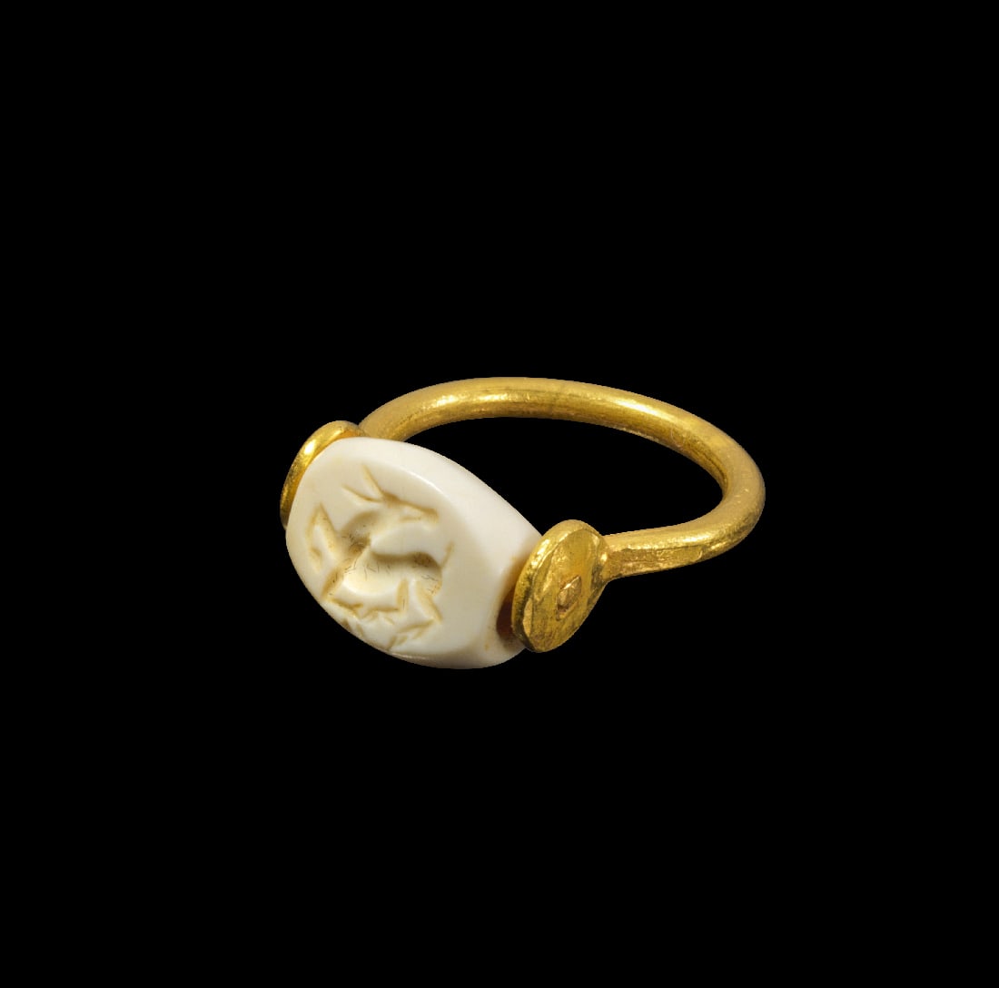 Moderner Goldring mit Steatit-Gemme mit Reh.: Moderner Goldring mit Steatit-Gemme mit Reh. Gemme Graeco-persisch, 5. Jh. v. Chr. 3,44g, Ringgroesse 43-44. Schiene aus Golddraht, die eine scaraboide Gemme aus weissem Steatit haelt, auf der ein spr