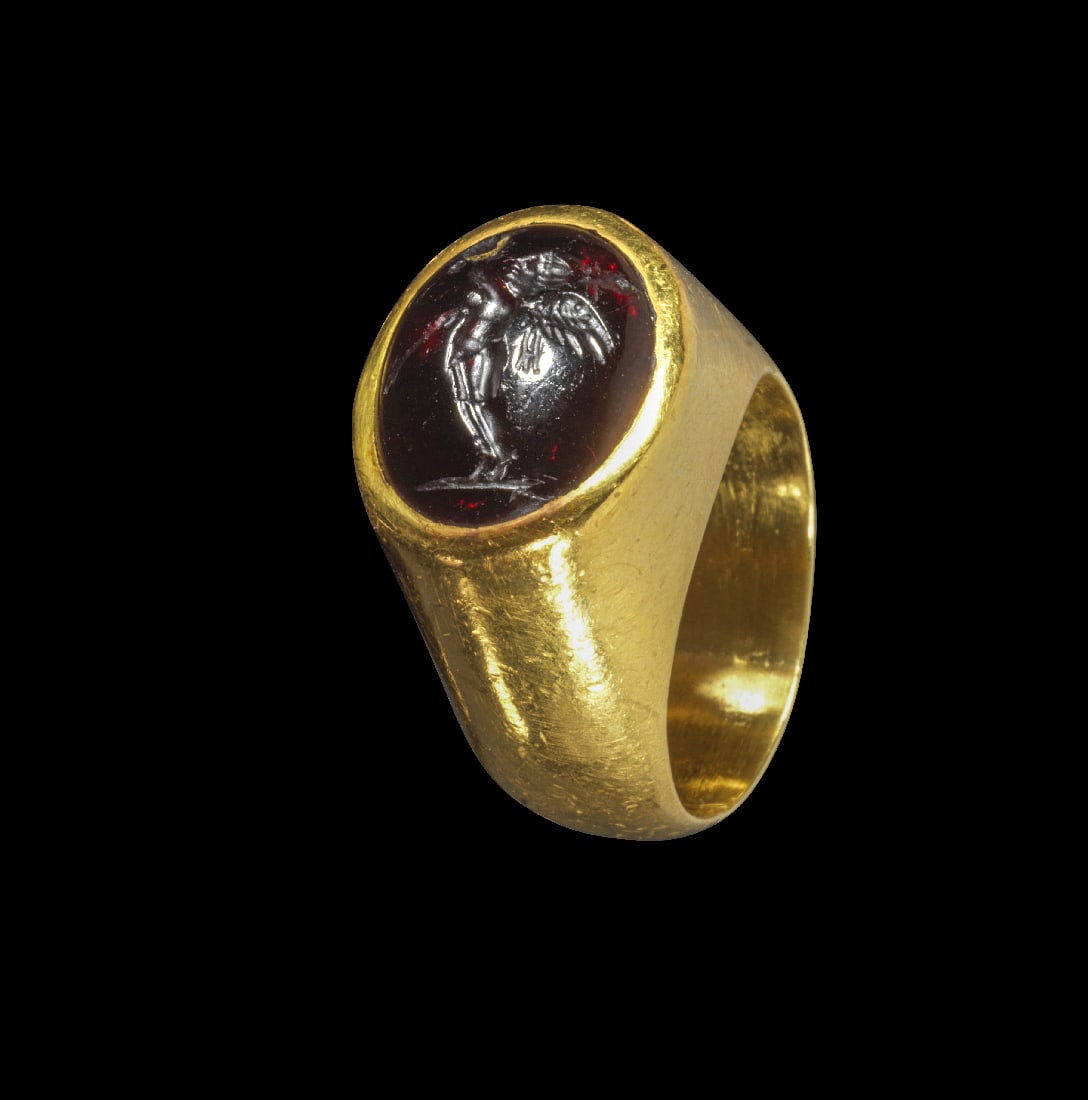 Moderner Goldring mit antiker Gemme.: Moderner Goldring mit antiker Gemme. Gemme, 1. Jh. v. Chr., Ring modern. 14,26g. Ringgroesse 52. Nach aussen konvexe, gleichmaessig breite Schiene mit hoher Fassung, darin eine gewoelbte Gemme aus Gra