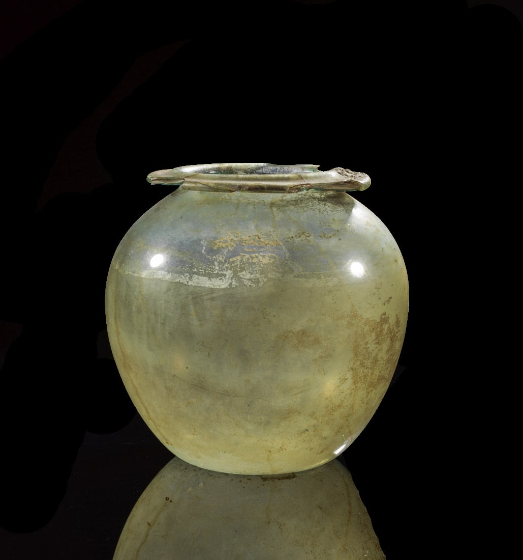 Grosse kugelige Glasurne.: Grosse kugelige Glasurne. Roemische Kaiserzeit, 1. - 2. Jh. n. Chr. H 25,9cm, ? 24,8cm. Leicht gruenliches transparentes Glas. Aus sehr duennem Glas mit zweifach umgeboerdelter Lippe. Mit Zertifikat u