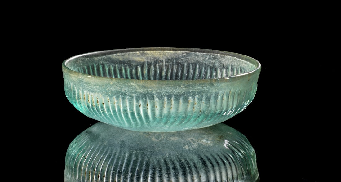 Rippenschale.: Rippenschale. Wahrscheinlich Italien oder oestlicher Mittelmeerraum, 1. Jahrhundert n. Chr. ?13,2cm. Blaeuliches transluzentes Glas. Die Aussenseite ist umlaufend mit zahlreichen feinen, vertikal
