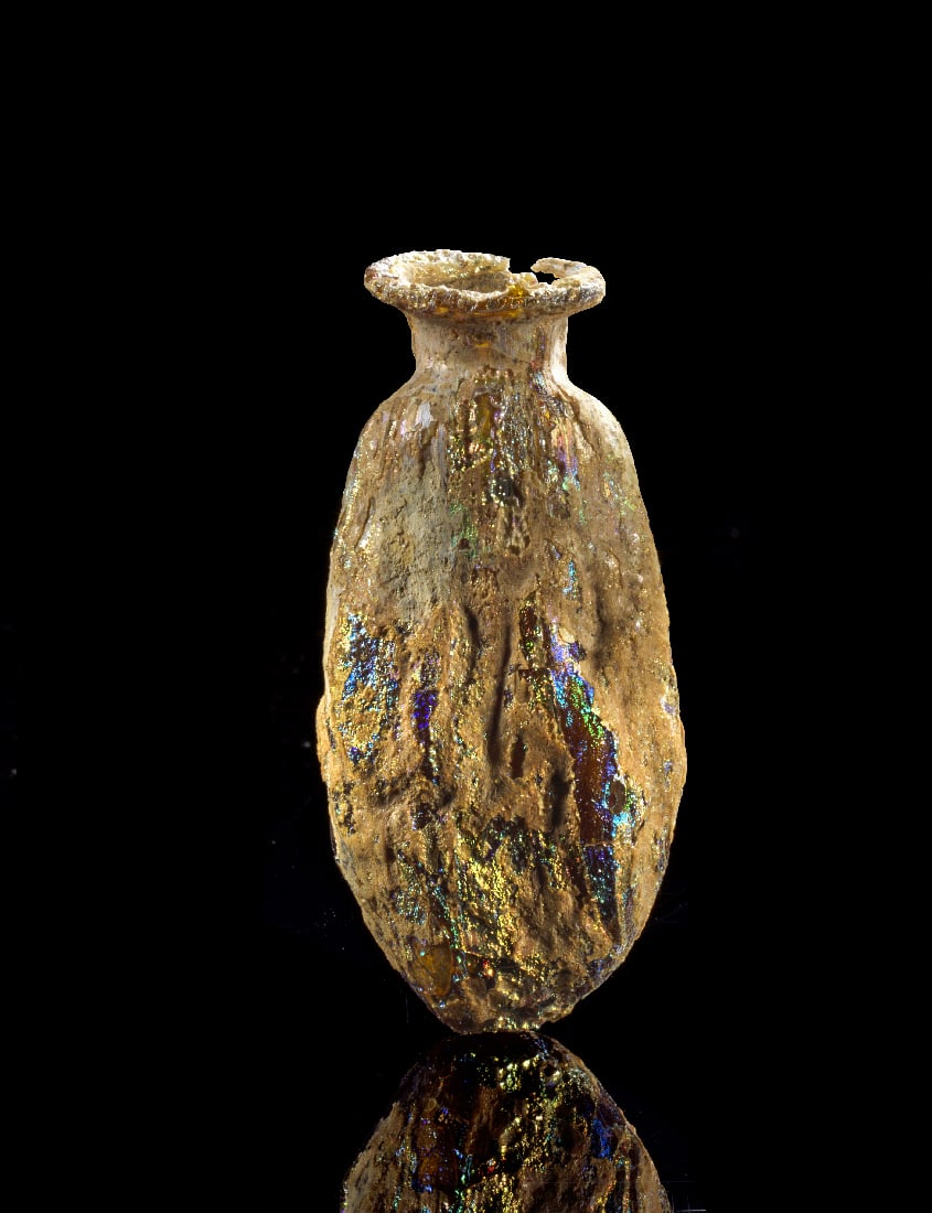 Bernsteinfarbene Dattelflasche.: Bernsteinfarbene Dattelflasche. Roemische Kaiserzeit, 1. - 2. Jh. n. Chr. L 6,5cm. Formgeblasen. Kurzer Hals mit umgeboerdelter Lippe. Herrliche Iris, winziges Fragment der Lippe fehlt. Provenienz: