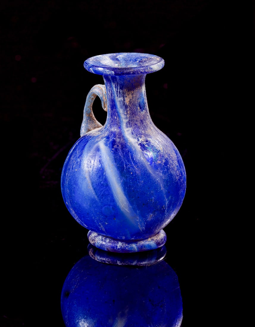 Miniatur-Amphoriskos.: Miniatur-Amphoriskos. Roemisch, 1. Jh. n. Chr. H 4,9cm. Aus blauem, hellblauem und weissem, opakem Glas. Bauchiger Corpus mit Standring, zylindrischem Hals und breiter Muendung mit nach aussen umgeboe