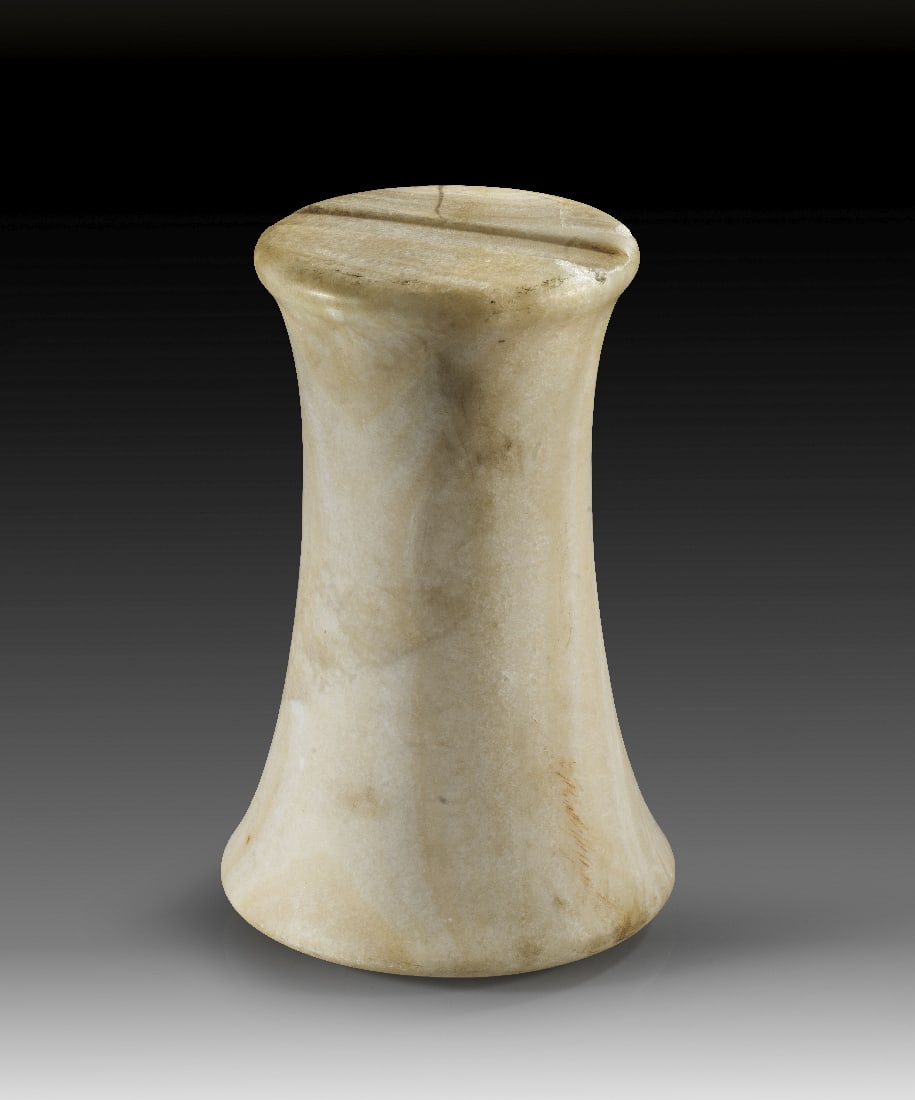 Miniatursaeule aus Calcit-Alabaster.: Miniatursaeule aus Calcit-Alabaster. Baktrien, 2. Jt. v. Chr. H 21,5cm, ? oben 11,5cm. Zur Mitte hin konisch verlaufende Miniatursaeule mit flachem Boden und flachem oberen Abschluss, in denen sich