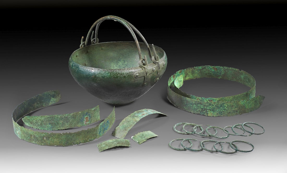 Spaetbronzezeitlicher Hortfund.: Spaetbronzezeitlicher Hortfund. Urnenfelderzeitlich, 1050 - 950 v. Chr. a) Herrliches Kreuzattaschenbecken mit graviertem und gepunztem Dekor am Rand. H 15,1cm, ? 26,7cm. Im Boden kleiner Ausbruch sow