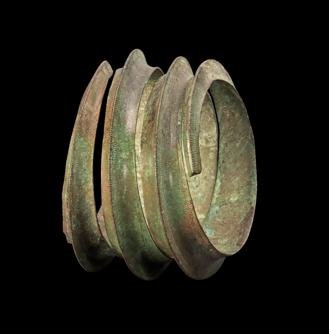 Bronzener Spiralarmreif.: Bronzener Spiralarmreif. Bronzezeit, ca. 9. - 7. Jh. v. Chr. ? ca. 8,5cm. Massiver, im Schnitt dreieckiger, zur Spirale aufgebogener Reif mit ziseliertem Dekor. Gruene Patina, ein winziges Fragment