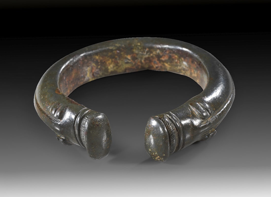 Massiver Bronzearmreif mit Eberkoepfen.: Massiver Bronzearmreif mit Eberkoepfen. Keltisch, 4. - 1. Jh. v. Chr. ? 6,8cm. Offener Armreif mit D-foermigem Querschnitt, beide Enden in Form von stilisierten Eberkoepfen. Exzellente, gruene Patina,