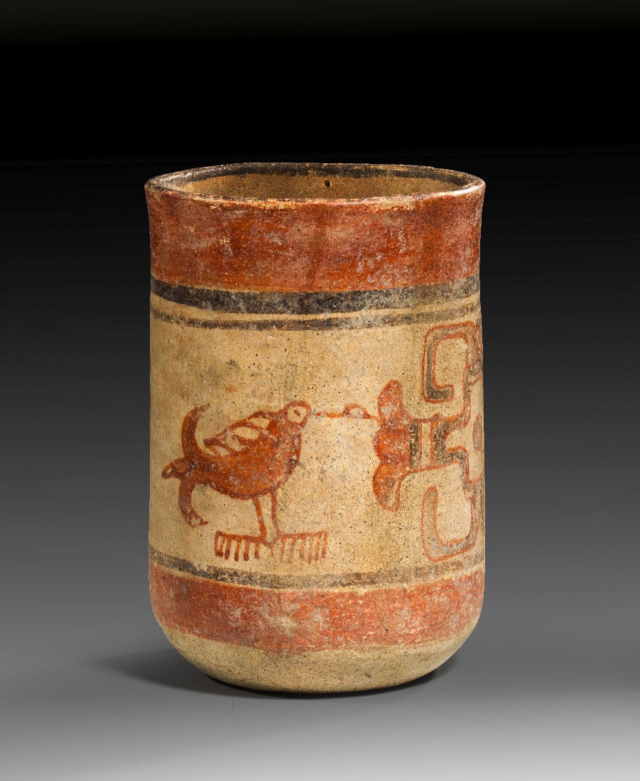 Becher mit Kolibris.: Becher mit Kolibris. Maya, ca. 900 n. Chr. H 18,5cm, ? 12cm. Ton mit Bemalung in Rottoenen und Schwarz auf ockerfarbenem Grund. Zylindrischer Becher mit der Darstellung zweier nach rechts gewandter