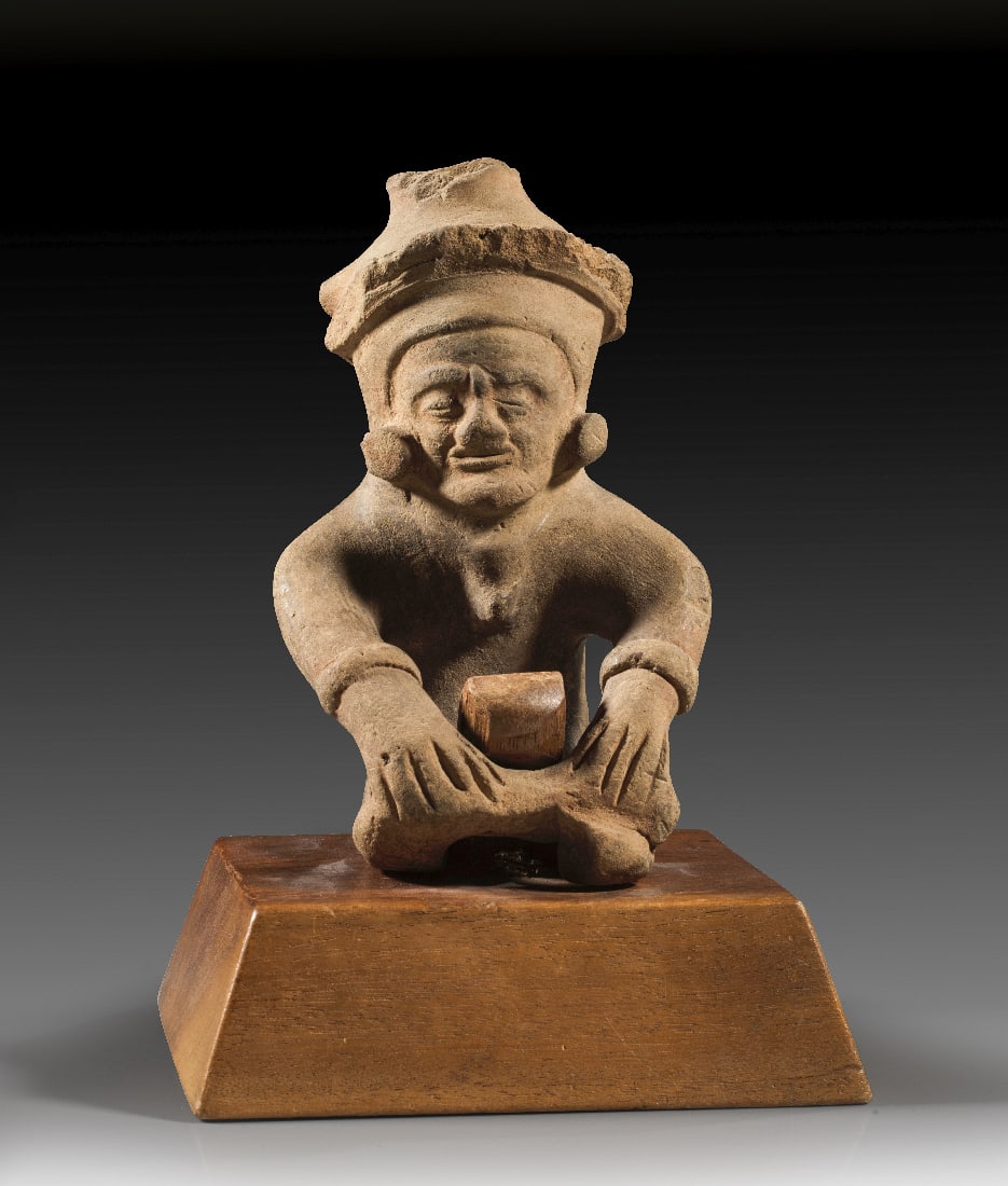 Sitzender Mann.: Sitzender Mann. Bahia, ca. 500 n. Chr. H 17cm, B 11cm. Hellbraune Terrakotta. Mit nachdenklichem Blick und uebers Knie geschlagenem Bein sitzende maennliche Figur mit grossen Scheibenohrringen und