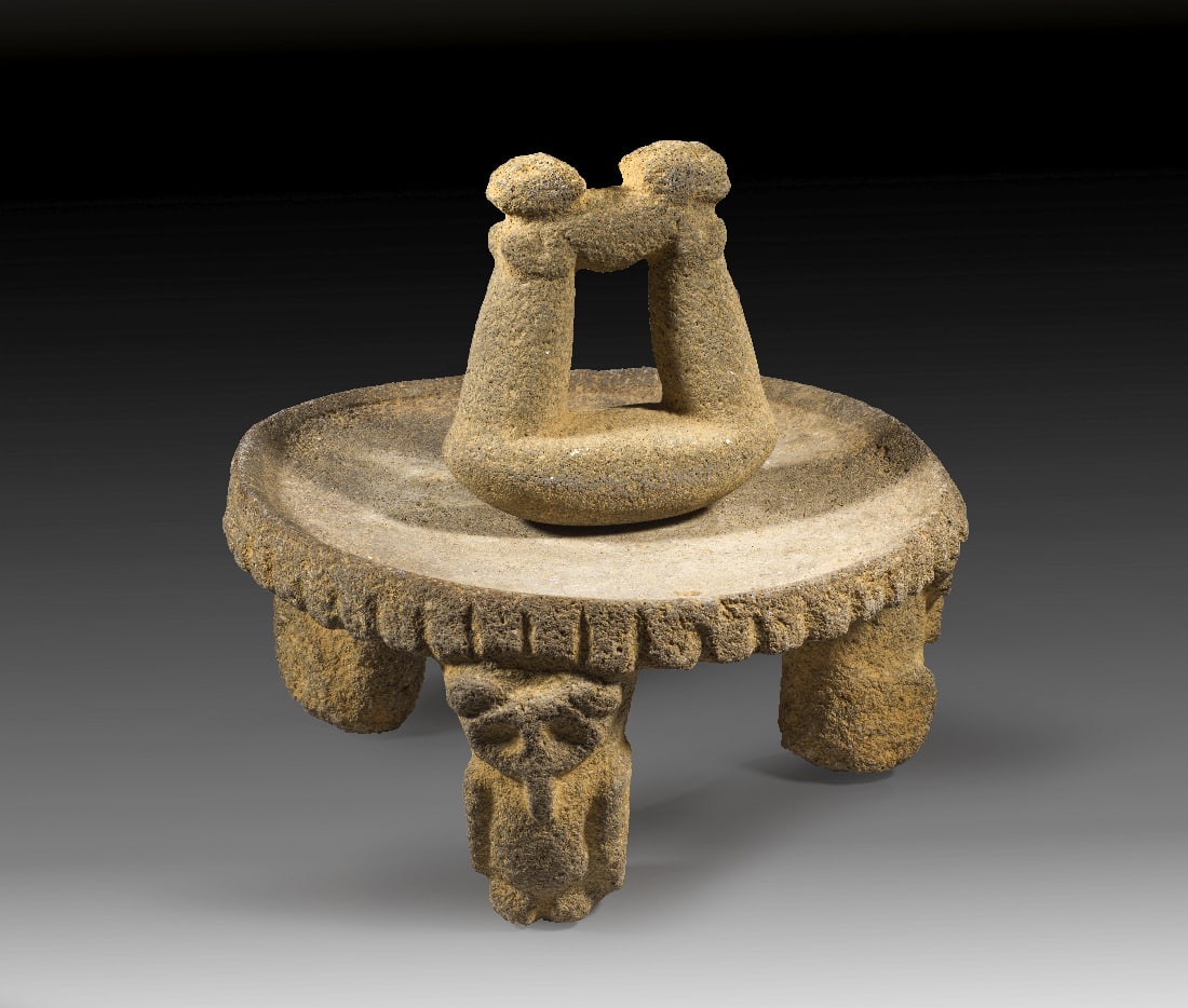 Reibeschale (metate).: Reibeschale (metate). Atlantische Abdachung, ca. 800 - 1200 n. Chr. H 15,5 cm, L 32,5cm. Grosse, flache Scheibe aus hellgrauem Vulkangestein mit geripptem Rand; die drei Fuesse sind als stehende